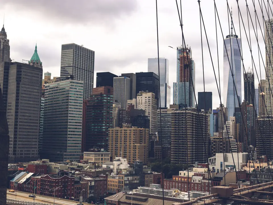 A dramatic view of the skyscrapers of New York City captured from the Brooklyn Bridge