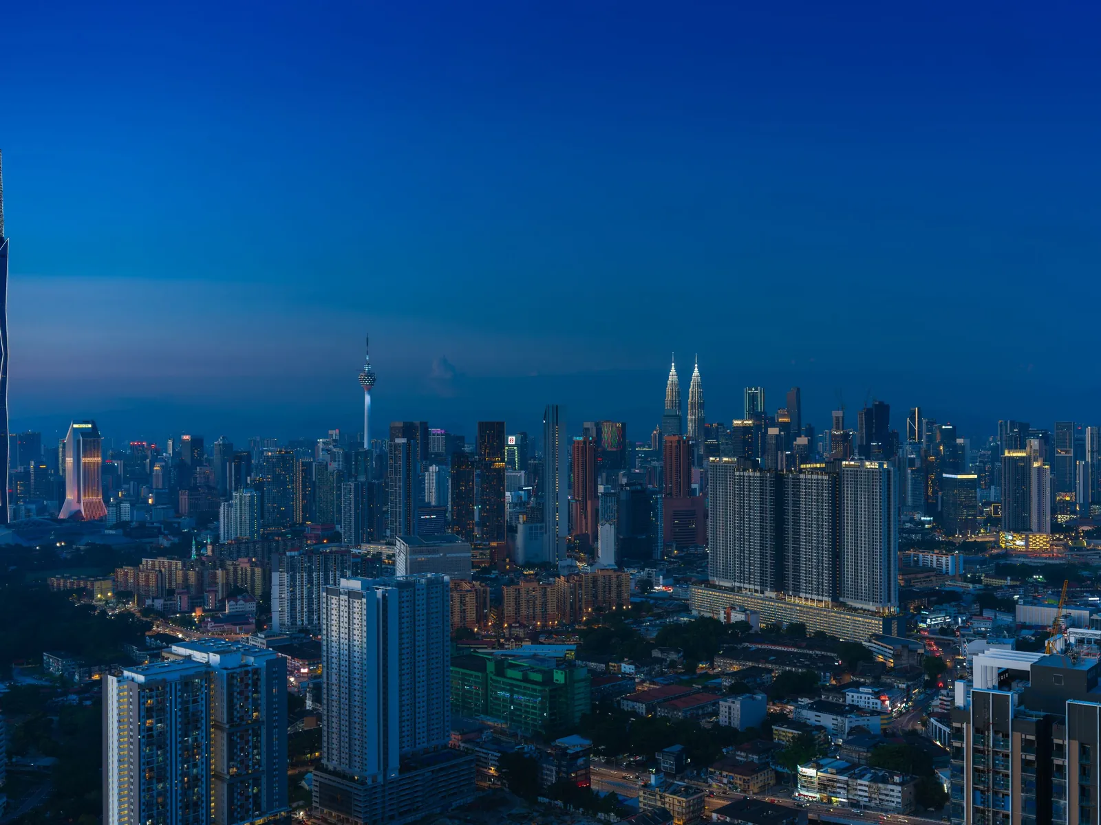 Discover the vibrant Kuala Lumpur skyline featuring iconic landmarks in the evening glow