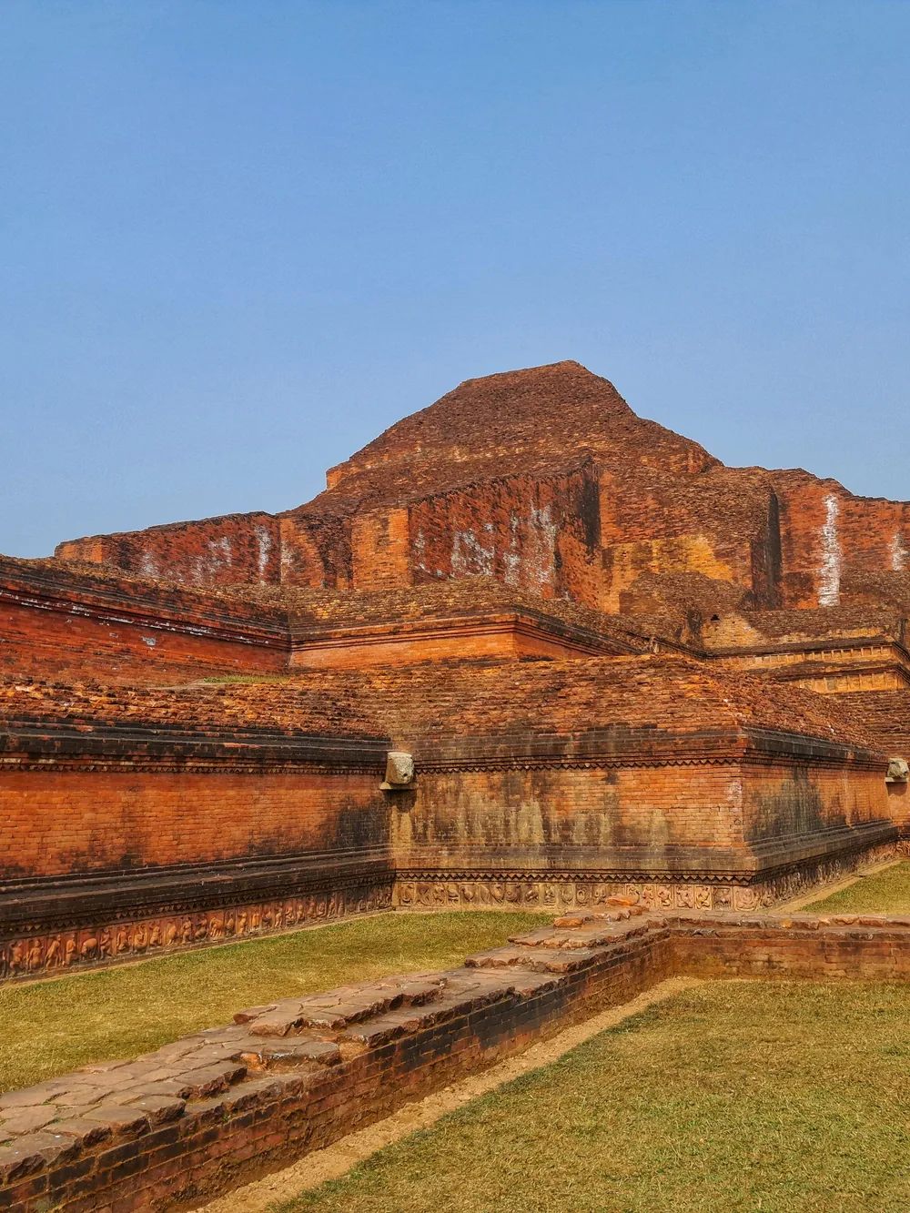 The red-brick mound of Nalanda's ancient stupa under open sky