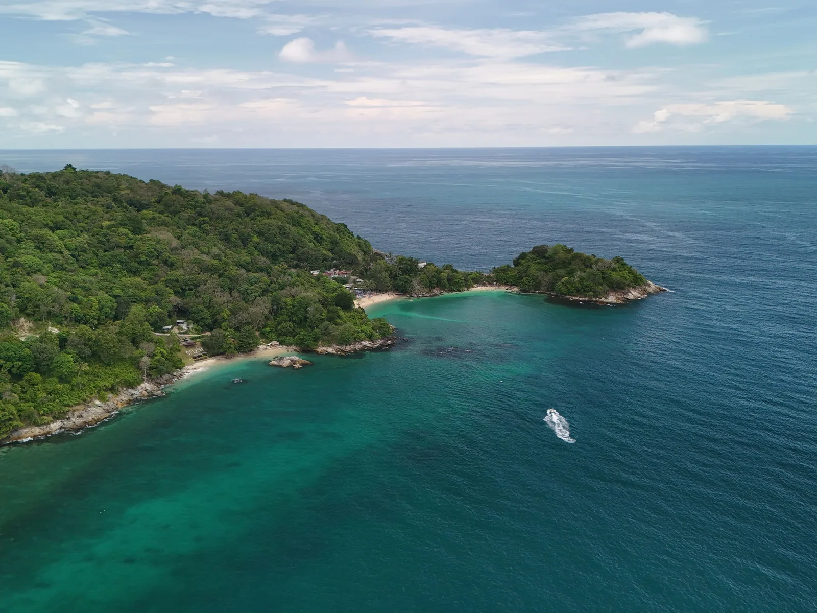A stunning aerial view of the tropical coastline with lush forests and azure waters in Phuket, Thailand