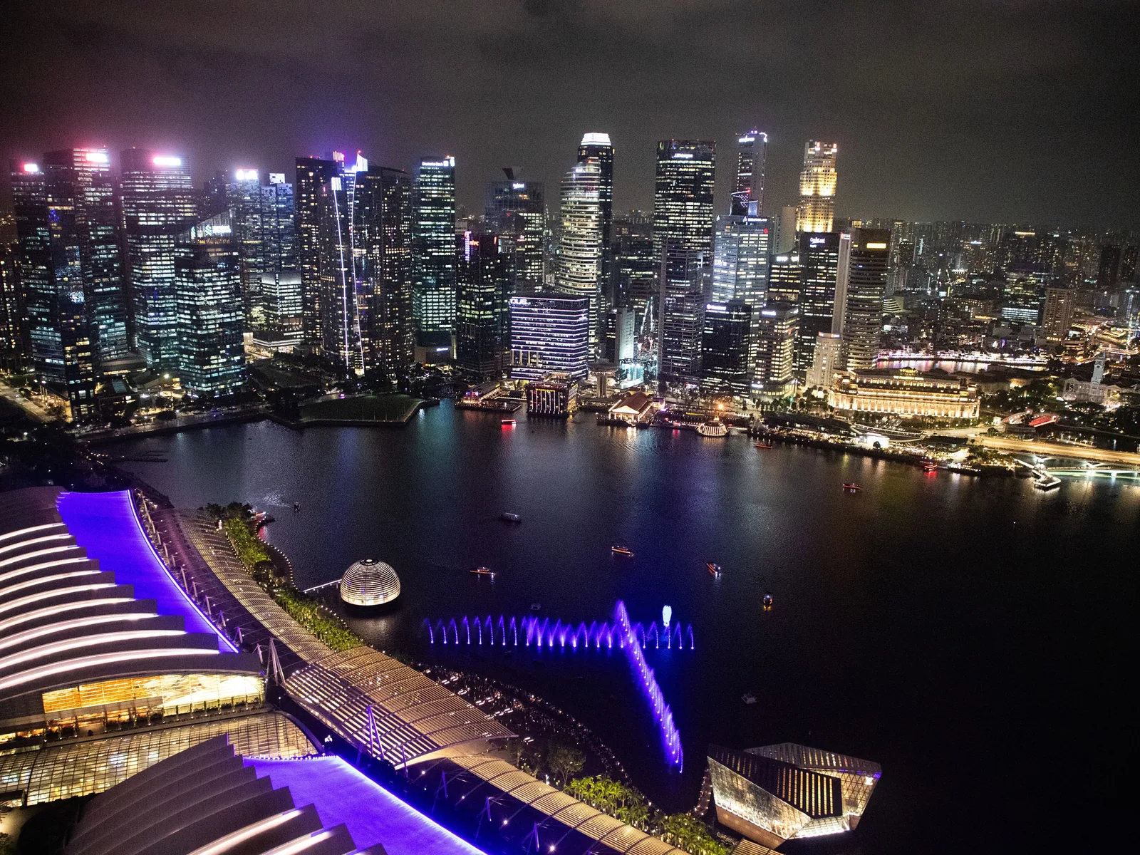 Breathtaking aerial view of Singapore's illuminated skyline at night, showcasing modern architecture and vibrant city life