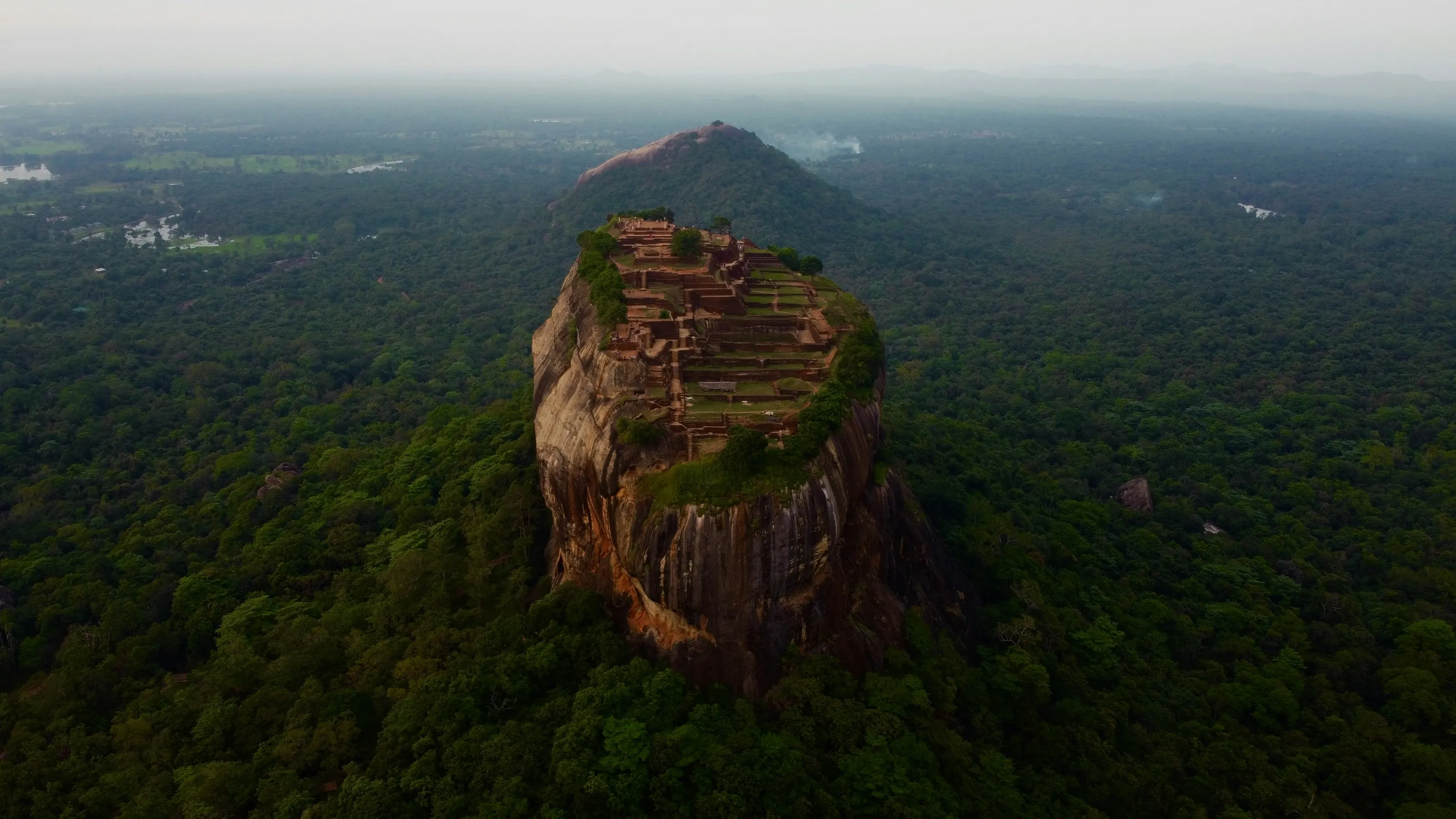 Sigiriya rock rising out of the forest, seen from the air