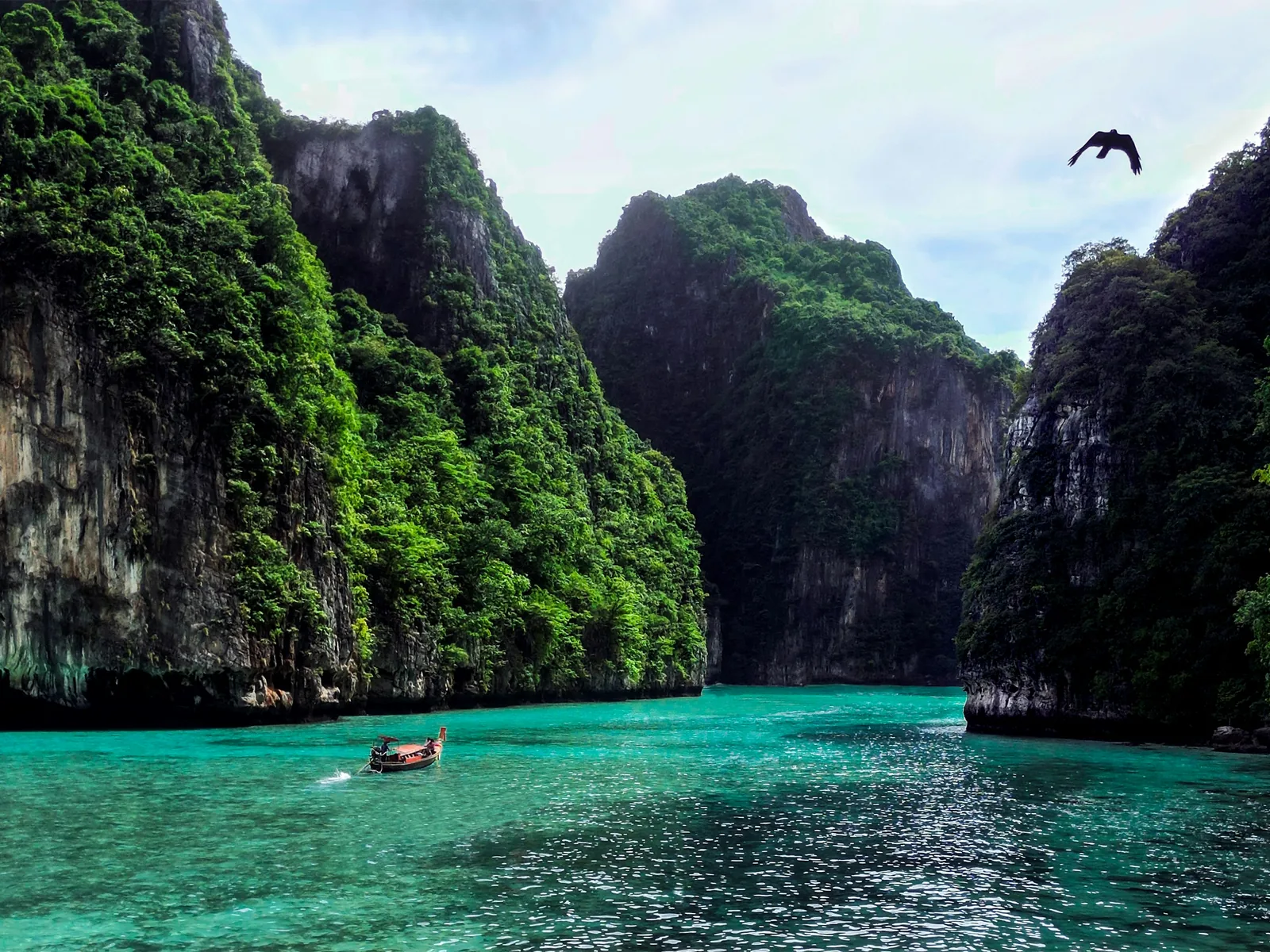 a person in a boat in a body of water surrounded by mountains
